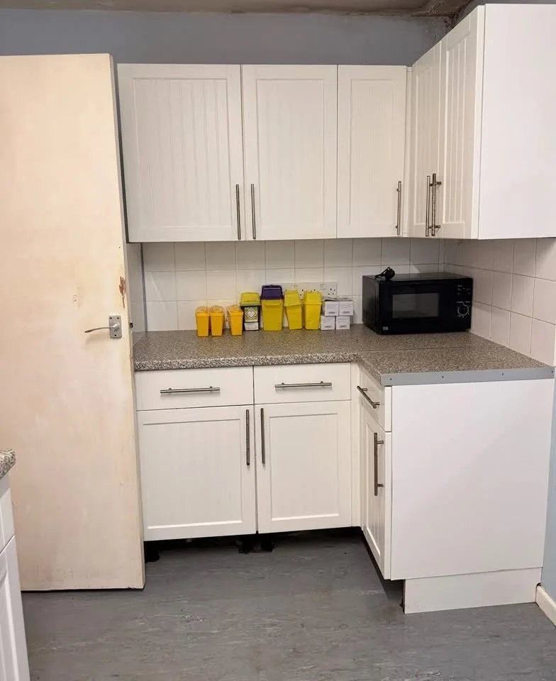 The same kitchen corner after cleaning: a tidy worktop, a cleared floor and a clean door.